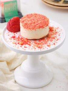 a small cheesecake sits on a cake stand