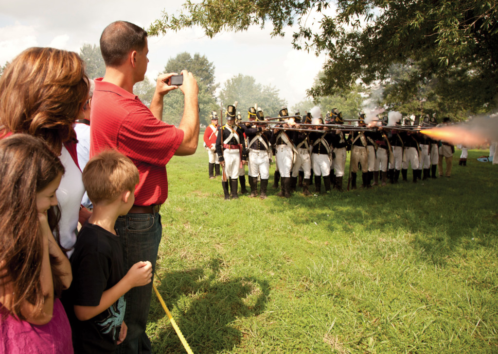 Person taking a photograph of marchers at Fort McHenry.