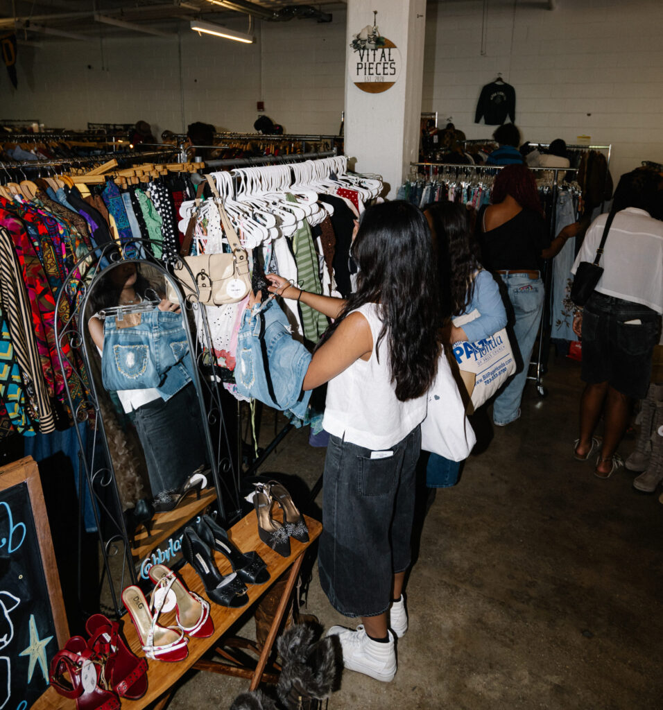 People sift through clothing at a vintage market