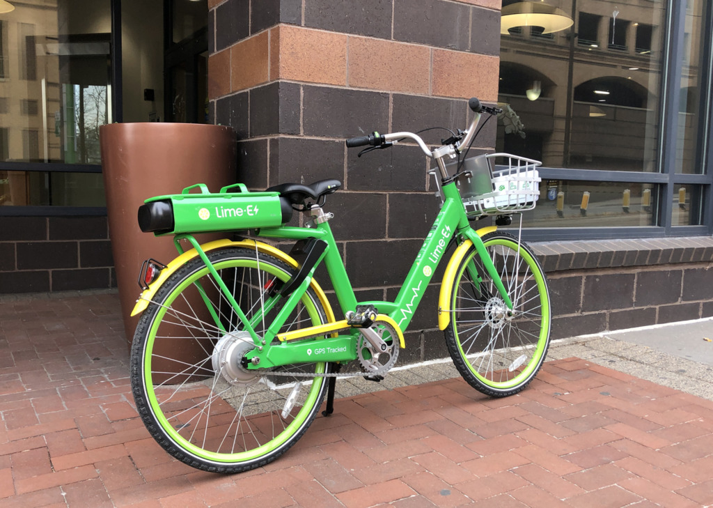 Green Lime Scooter against brick wall