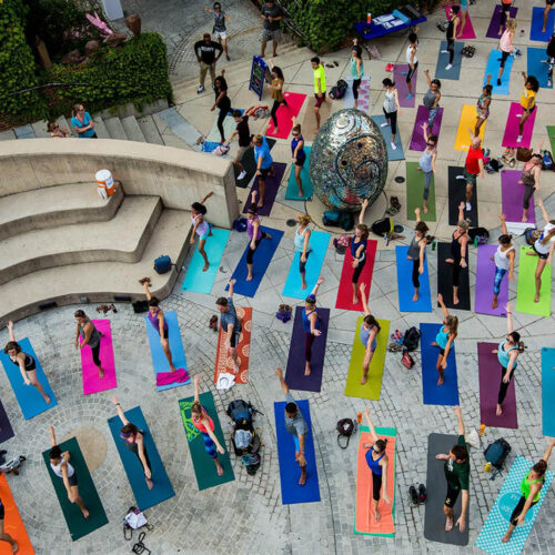 People doing yoga outside on colorful mats from above at AVAM in Baltimore.