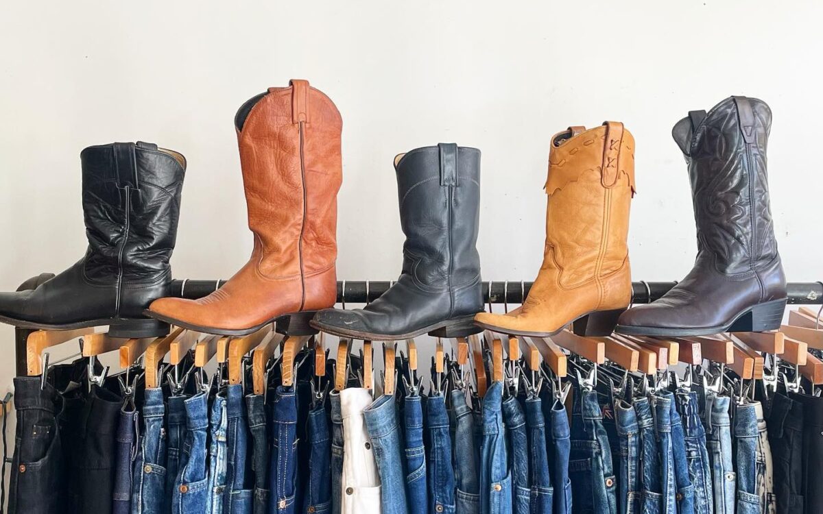 A rack of jeans with cowboy boots on top