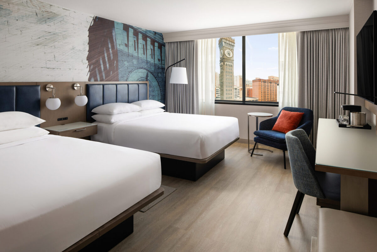 The newly renovated Queen/Queen Room offers a stylish and comfortable retreat featuring modern furnishings, plush bedding, luxury vinyl flooring, a spacious workstation, and convenient amenities including a 55-inch Smart TV with streaming, mini-refrigerator, coffee maker, and high-speed Wi-Fi.