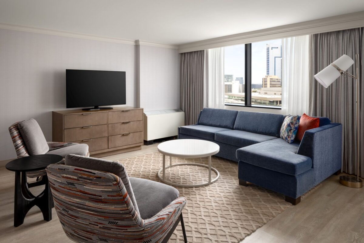 Relax and entertain in the stylishly renovated Executive Parlor. Featuring a comfortable sectional sofa, modern lounge seating, sleek coffee table, and work area, the space offers a sophisticated setting with large windows providing natural light and views of downtown Baltimore.