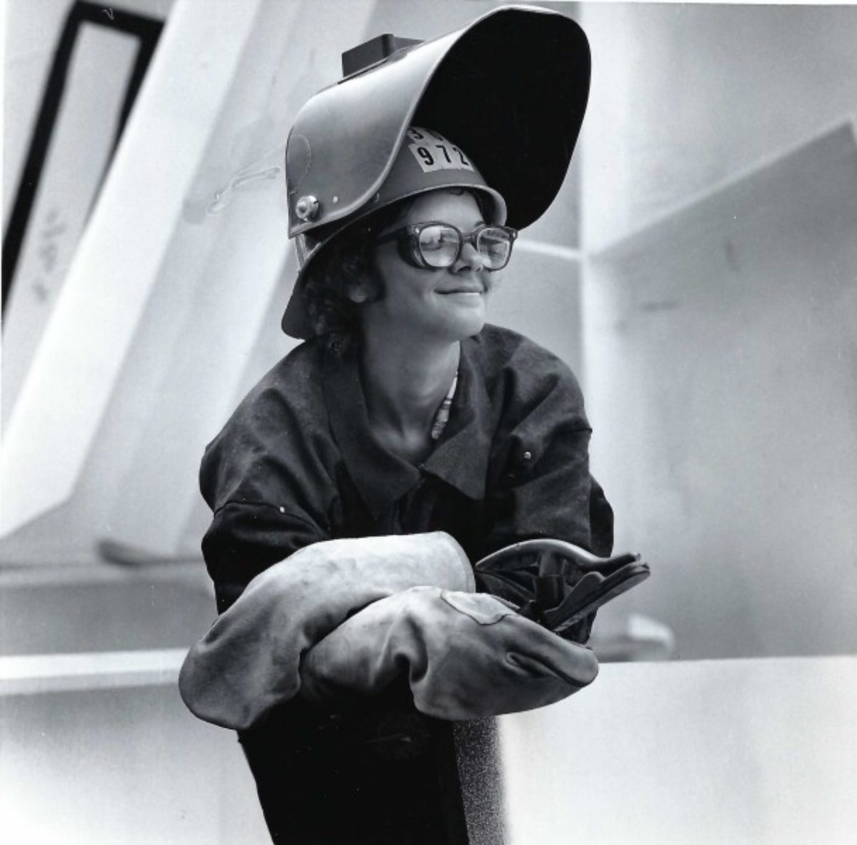 Vintage photo of a female welder wearing helmet