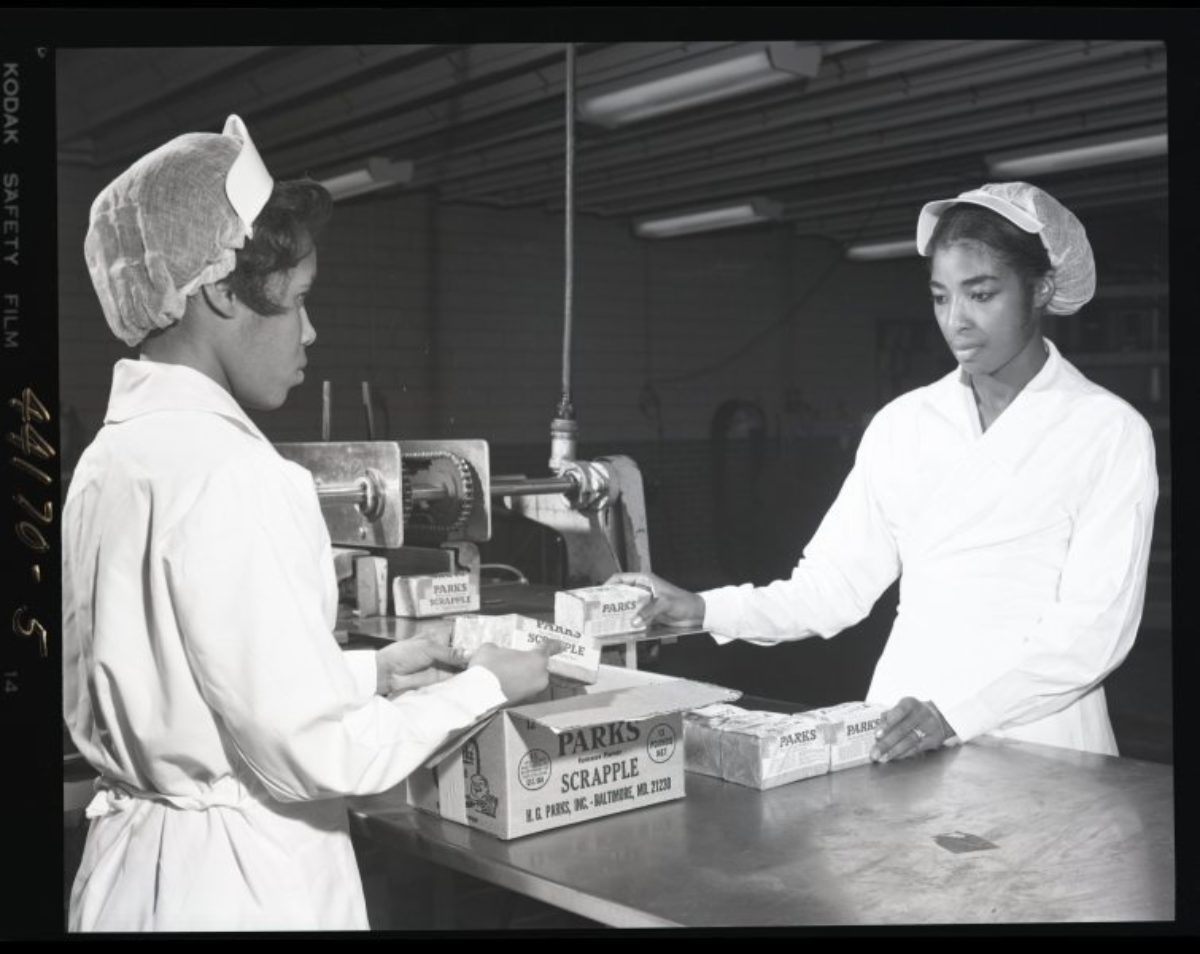 Vintage black and white photo of two women packing a box at a sausage factory