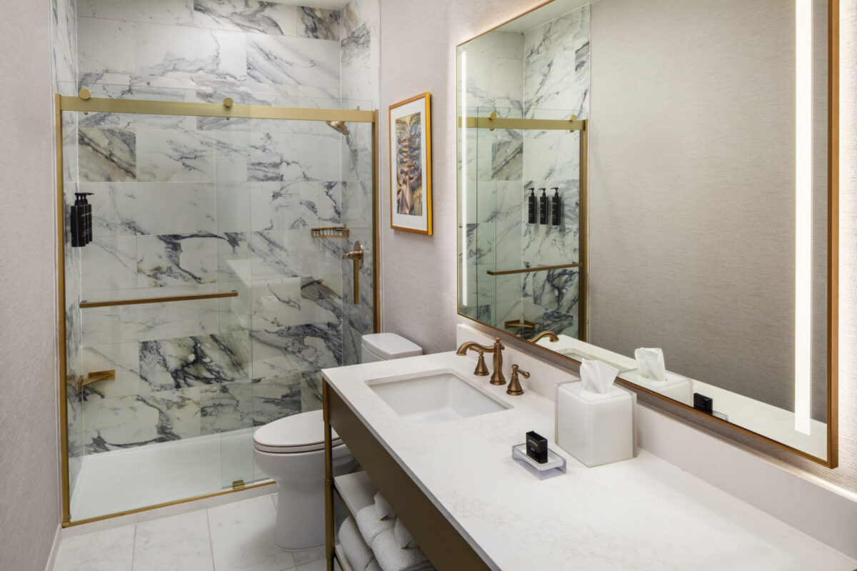Discover modern elegance in the newly renovated bathrooms at The William Fell Baltimore, Tapestry Collection by Hilton. Each space is thoughtfully designed with sleek, contemporary finishes and a clean, sophisticated aesthetic. The highlight: a spacious walk-in shower with glass enclosure, featuring upscale fixtures and a soothing rainfall showerhead. Accented with polished tile, ample lighting, and refined details, these bathrooms offer a spa-like atmosphere that complements the hotel’s signature blend of historic charm and modern comfort.