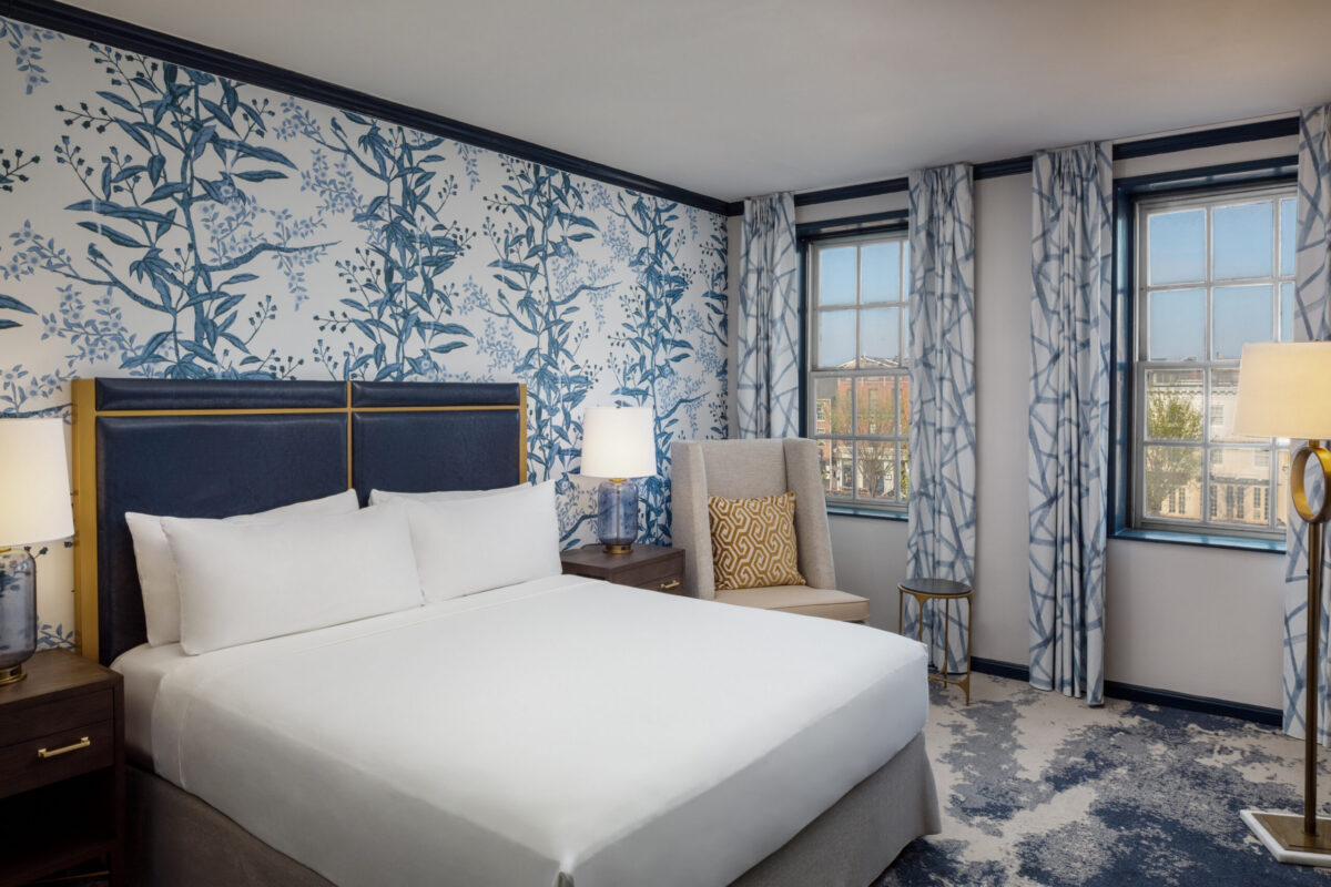 Step into refined comfort in this elegantly appointed guest room at The William Fell Baltimore, part of the Tapestry Collection by Hilton. Featuring a plush king-sized bed with crisp linens and stylish accent pillows, the room blends historic charm with modern sophistication. Warm wood tones, locally inspired artwork, and soft lighting create an inviting atmosphere. Thoughtful amenities include a cozy seating area, sleek work desk, and contemporary bathroom, making it ideal for both leisure and business travelers seeking a unique Baltimore stay.