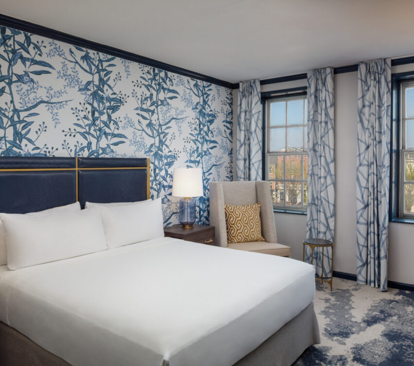 Step into refined comfort in this elegantly appointed guest room at The William Fell Baltimore, part of the Tapestry Collection by Hilton. Featuring a plush king-sized bed with crisp linens and stylish accent pillows, the room blends historic charm with modern sophistication. Warm wood tones, locally inspired artwork, and soft lighting create an inviting atmosphere. Thoughtful amenities include a cozy seating area, sleek work desk, and contemporary bathroom, making it ideal for both leisure and business travelers seeking a unique Baltimore stay.