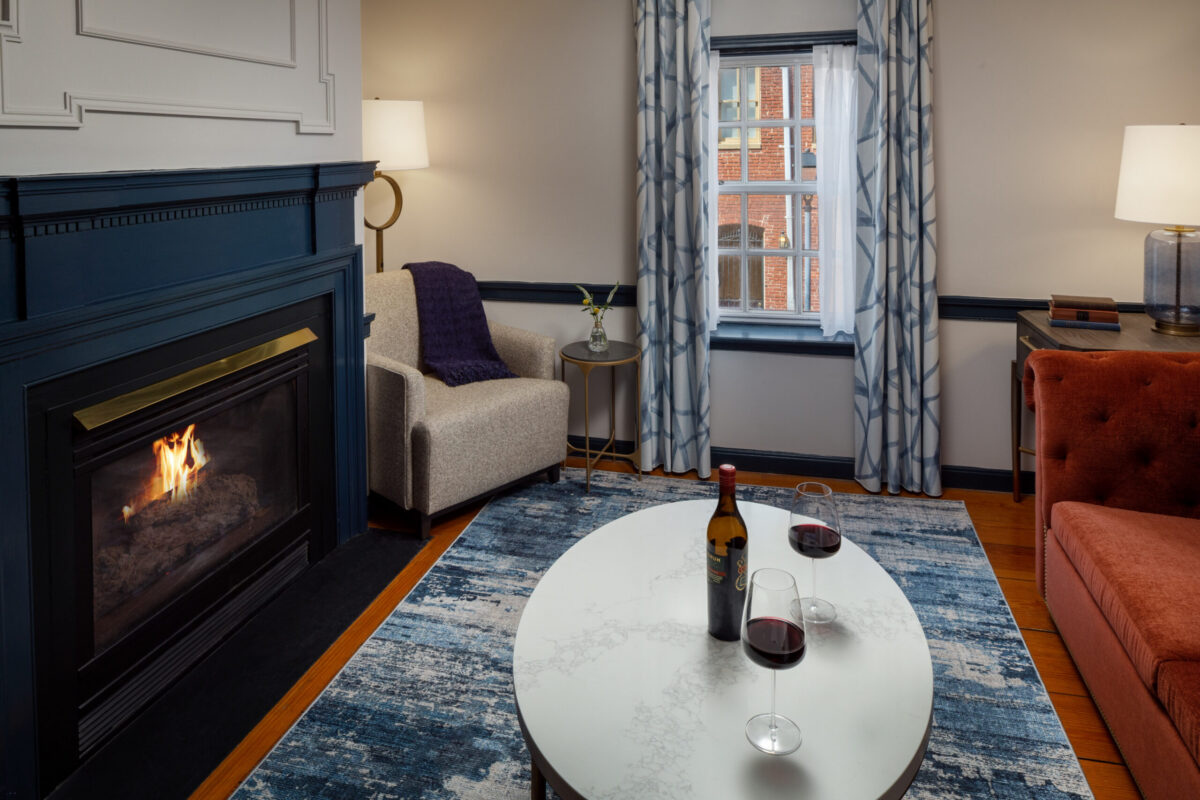 Indulge in elevated comfort and timeless elegance in the Presidential Suite at The William Fell Baltimore, Tapestry Collection by Hilton. This signature space invites relaxation with a beautifully appointed living area centered around a warm, inviting fireplace—perfect for unwinding with a glass of wine. Rich textures, curated décor, and thoughtful lighting create a serene ambiance, while the suite’s spacious layout offers refined luxury and privacy. Whether you're celebrating a special occasion or simply savoring a quiet evening, this suite offers a uniquely Baltimore blend of charm, sophistication, and relaxation.