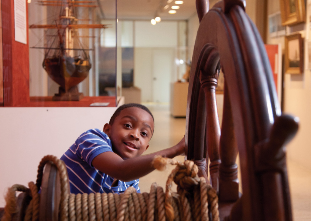 Boy playing with a ships wheel at the Maryland Historical Society