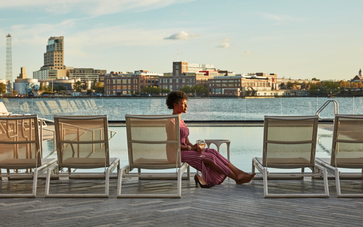 A woman enjoying a cocktail at the Pendry Hotel Pool in Fells Point.