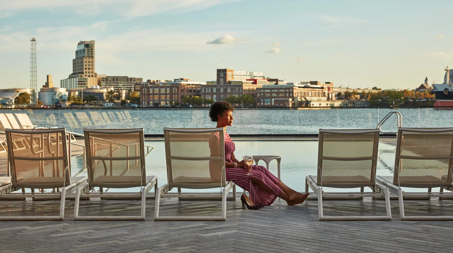 A woman enjoying a cocktail at the Pendry Hotel Pool in Fells Point.