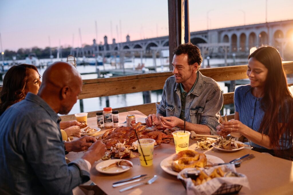 people eating crabs outside at sunset