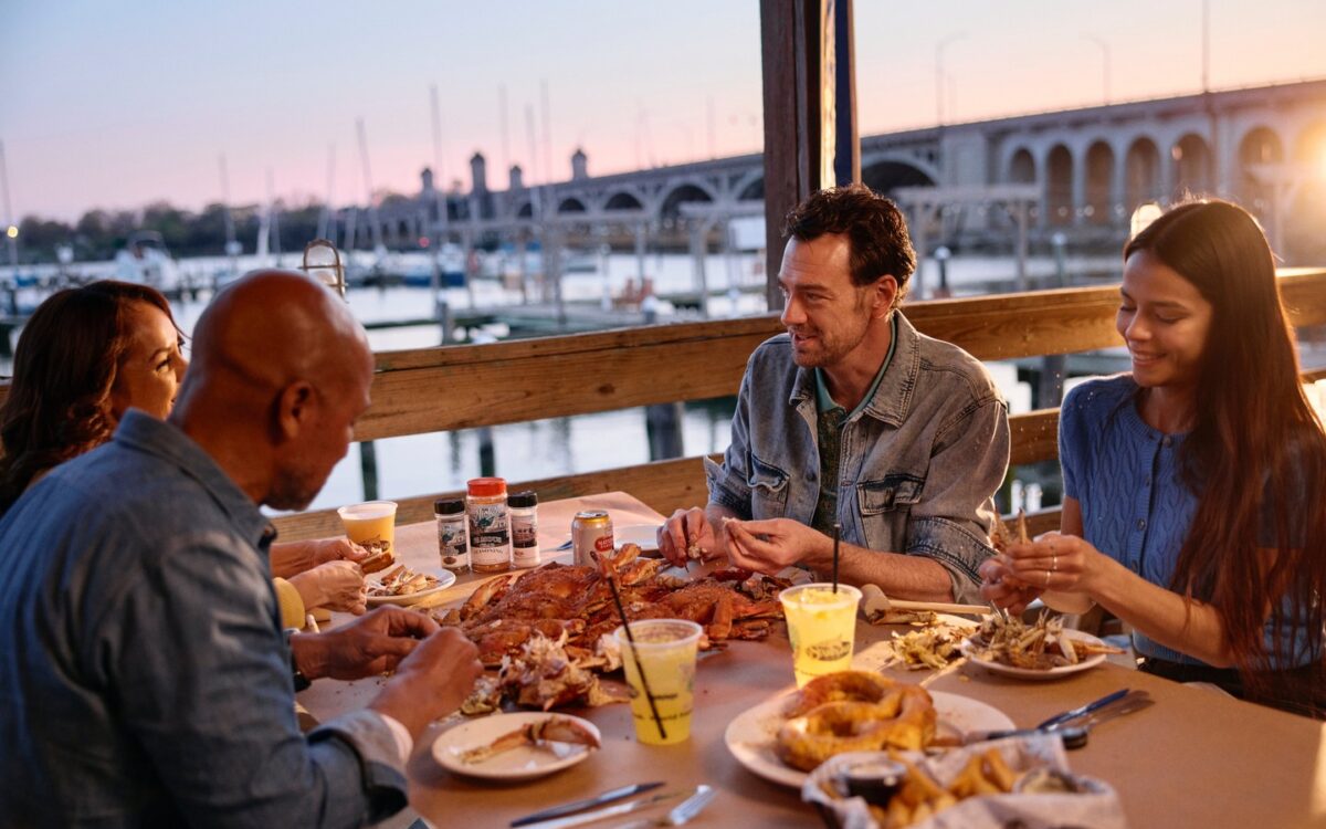 people eating crabs outside at sunset