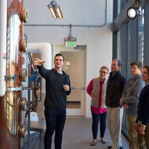 A group of people on a tour of a distillery
