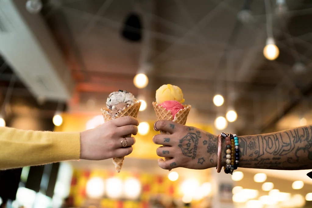 Two people hold colorful ice cream cones