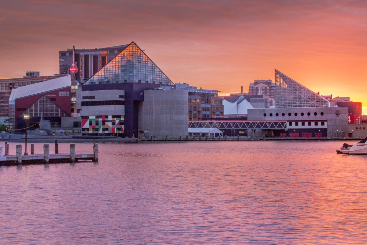Exterior of the the National Aquarium at sunset seen from the harbor.