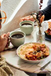 Two cups of coffee and grits on a table