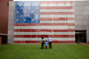 Visitors stare at an American flag