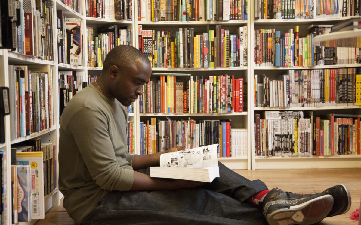 Man sits and reads a book at Atomic Books in Hampden