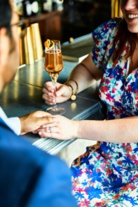 Two people holding hands with cocktail