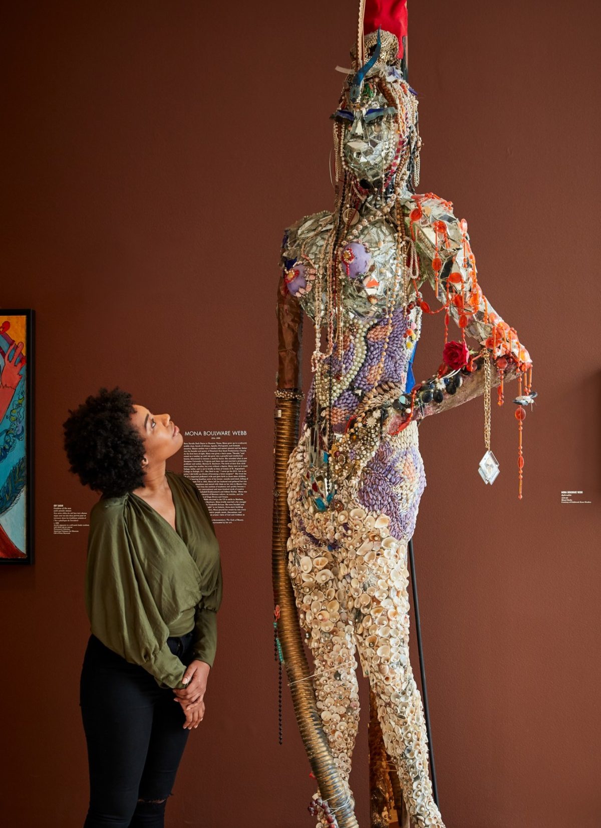 A woman admires a bejeweled statue at the American Visionary Art Museum