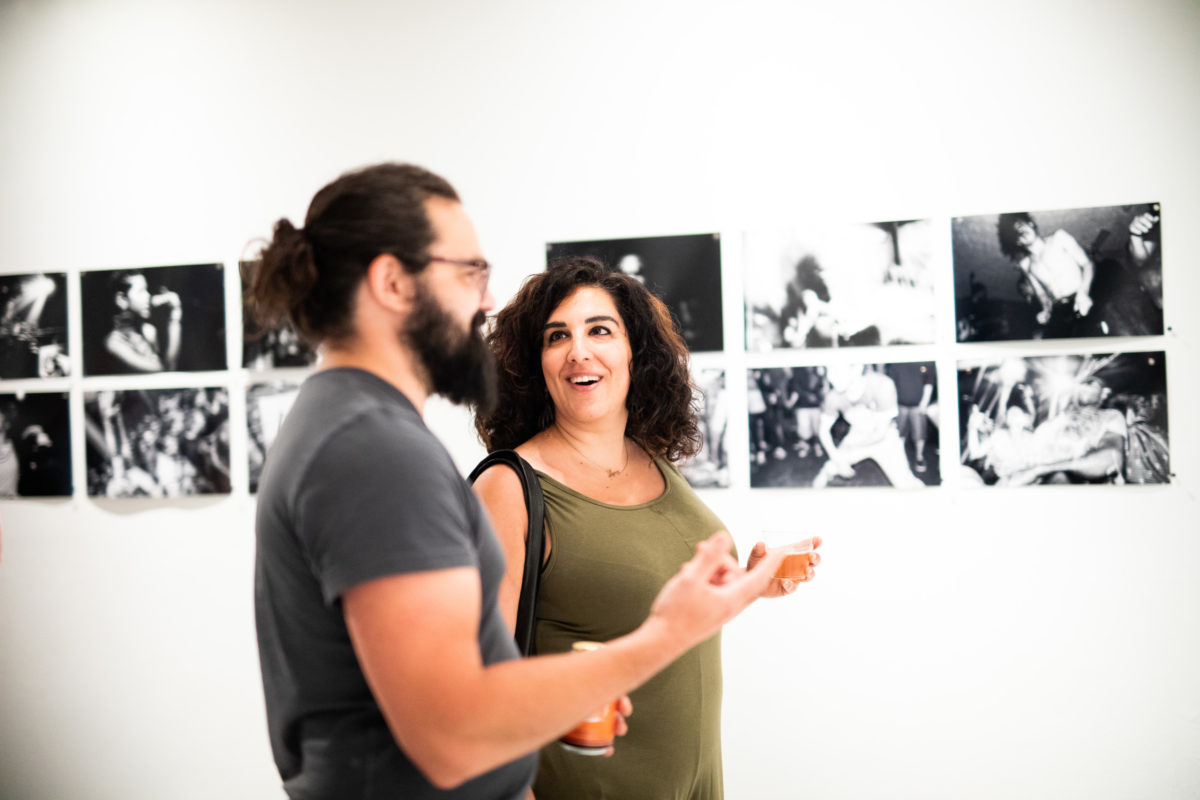 A man (left) and a woman (right) discuss black and white art pieces in Maryland Art Place.