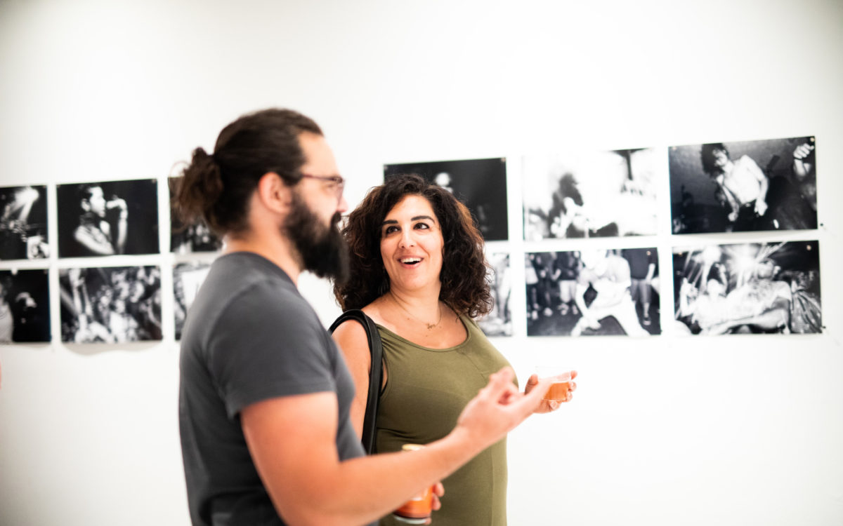 A man (left) and a woman (right) discuss black and white art pieces in Maryland Art Place.