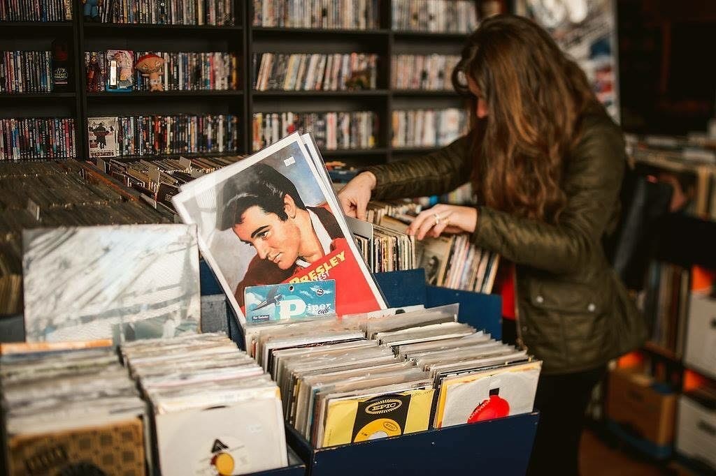A woman picks up an Elvis album in Protean Books & Records