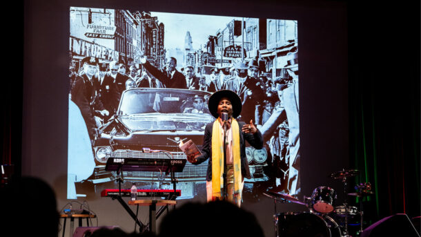 a poet speaks against a black and white vintage photograph background