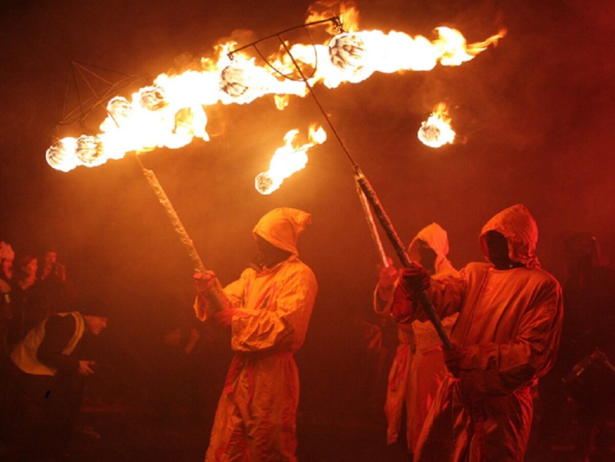 Men holding sticks with fire