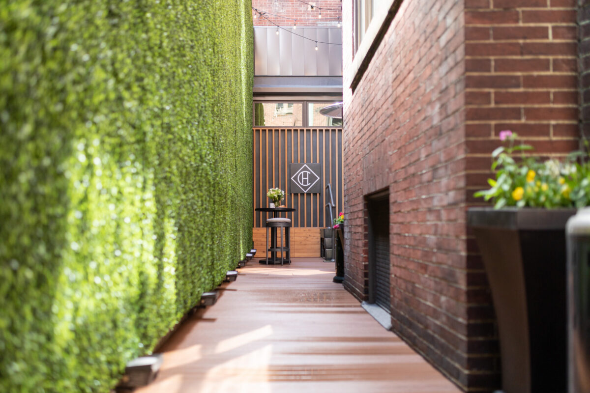 A private, enclosed Courtyard bordered on one side with faux greenery and offering an intimate setting for up to 15 to gather.