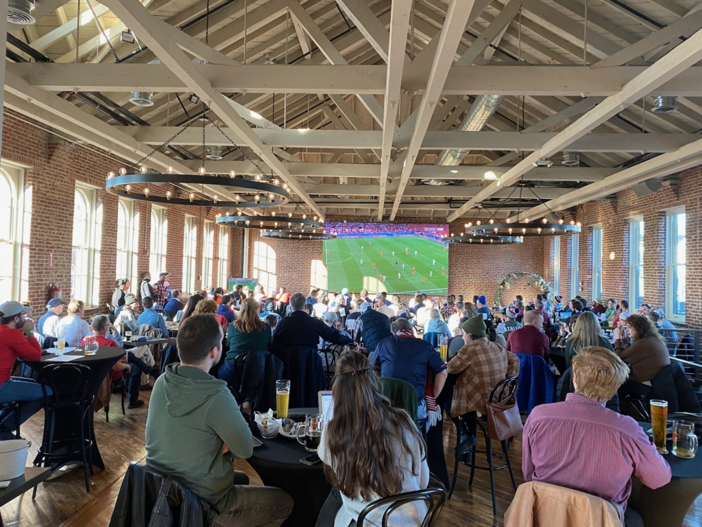 Crowd watches soccer at open-air brewery