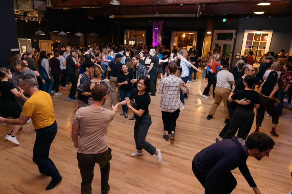 A crowd dances in an open ballroom