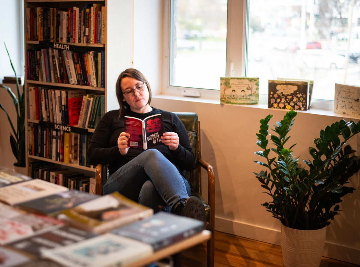 A woman reads a book in a bookstore