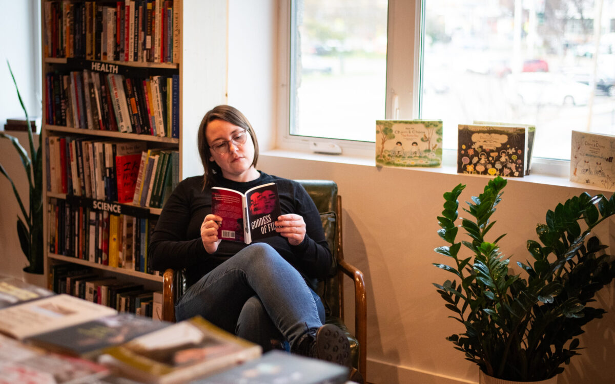 A woman reads a book in a bookstore