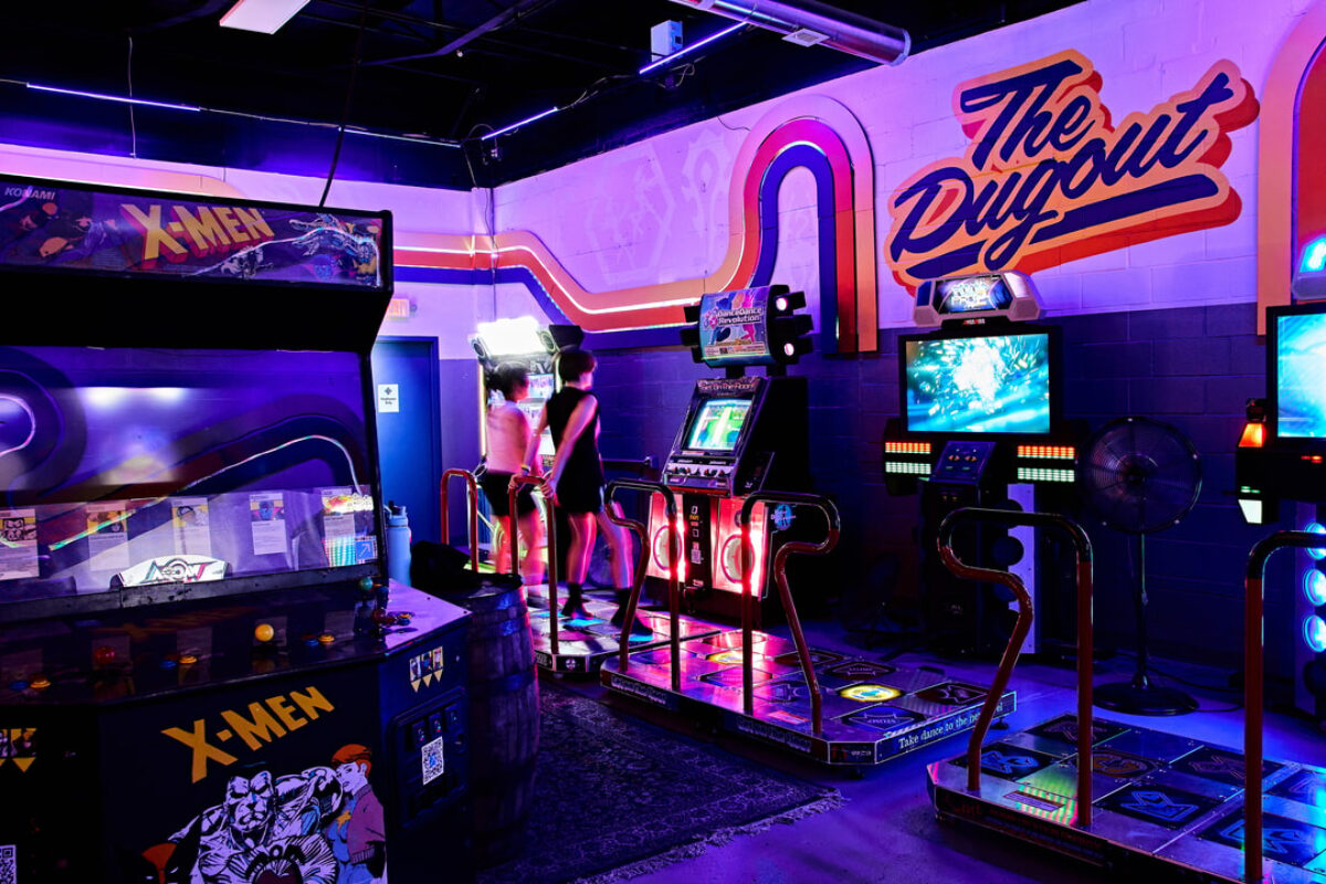 Two people play dance dance revolution in a dimly-lit room