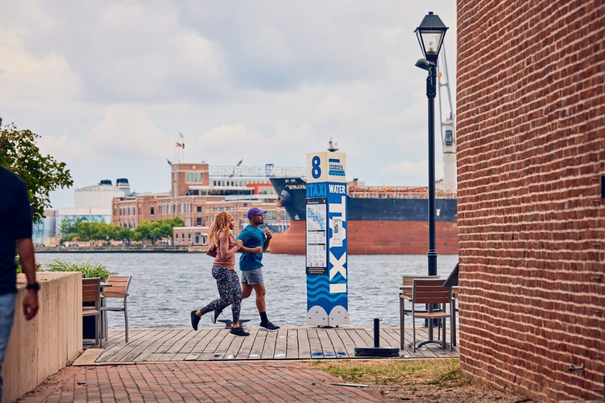 Two people running along the water