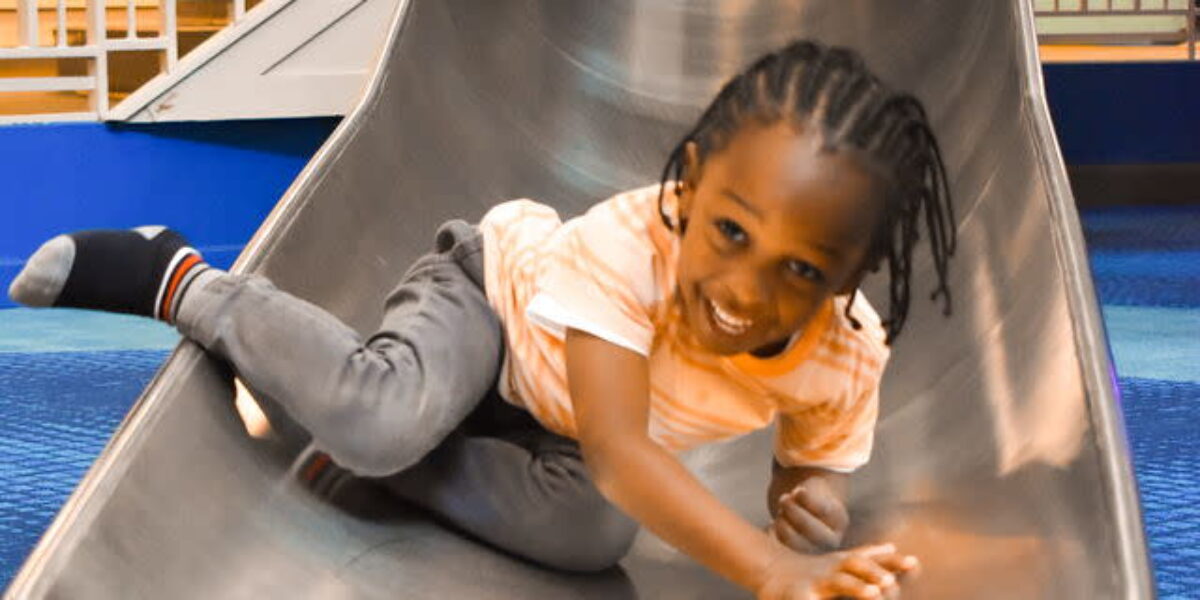 child sliding down a slide