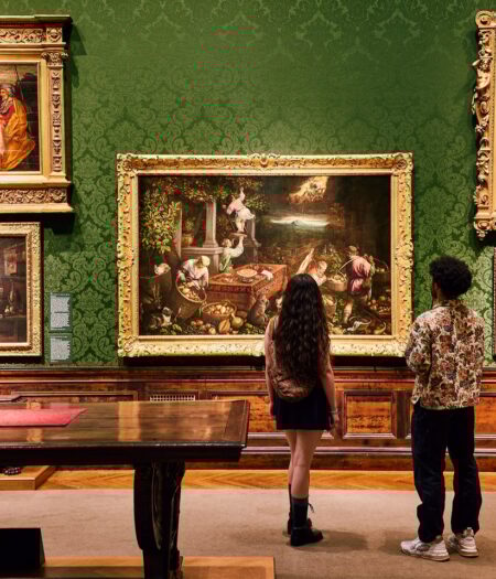 two people standing looking at art on the wall