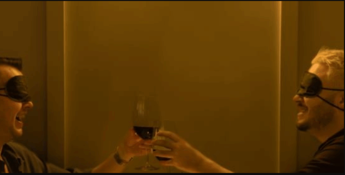 2 men with blindfolds cheersing wine