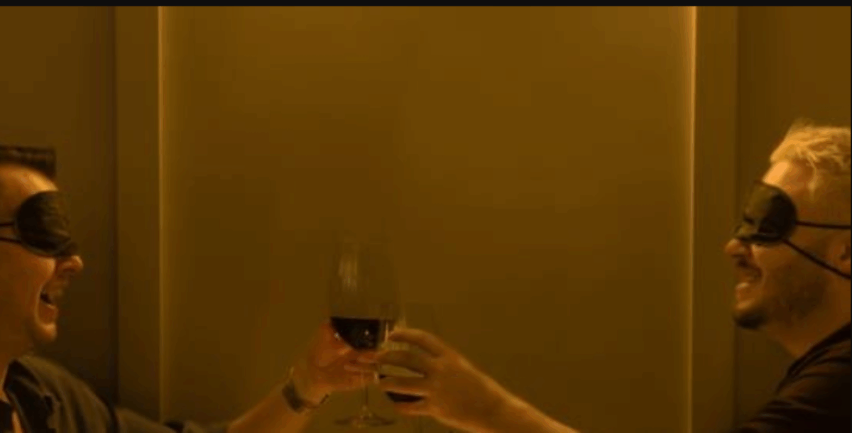 2 men with blindfolds cheersing wine