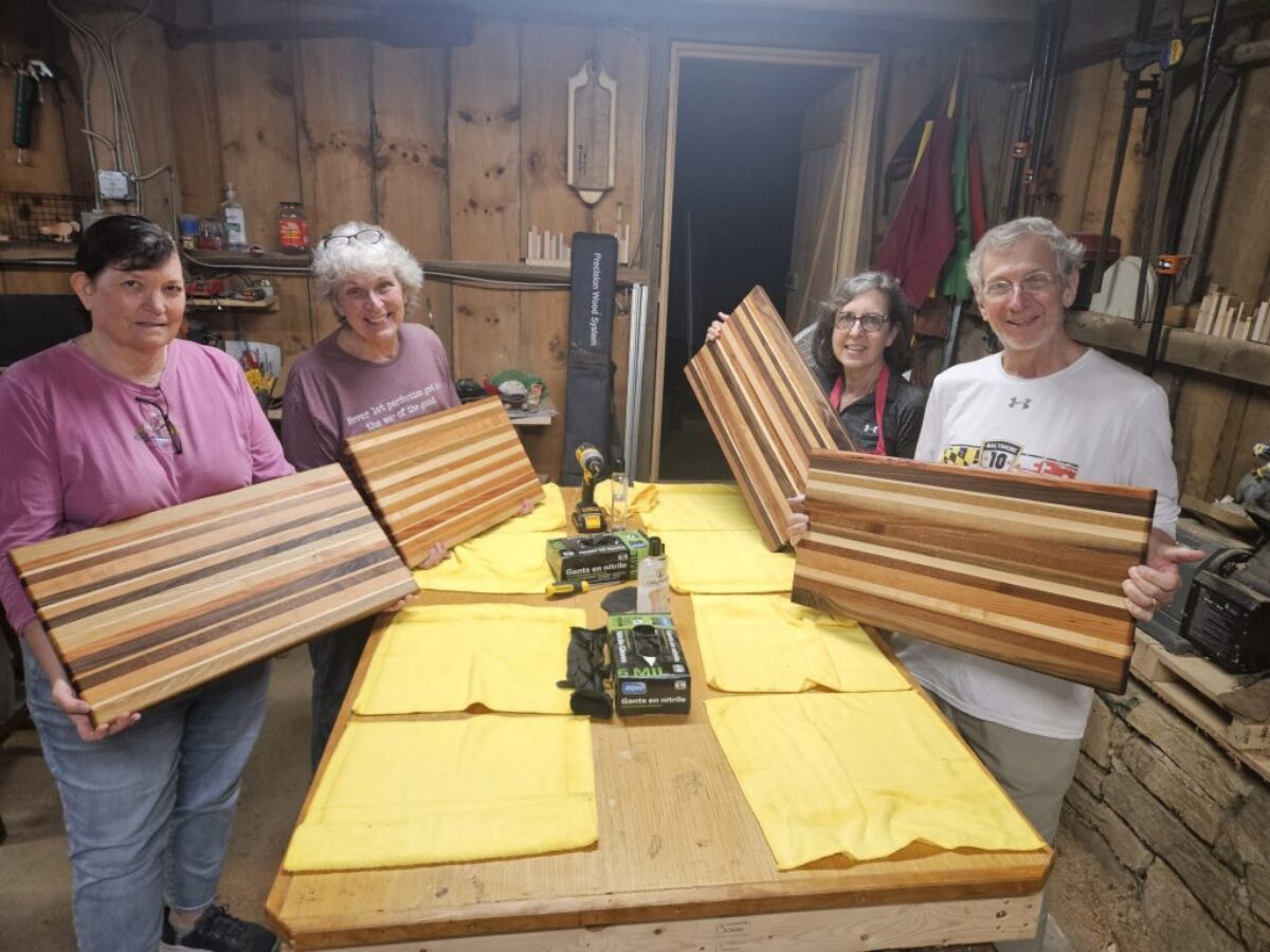 4 people holding holding cutting boards