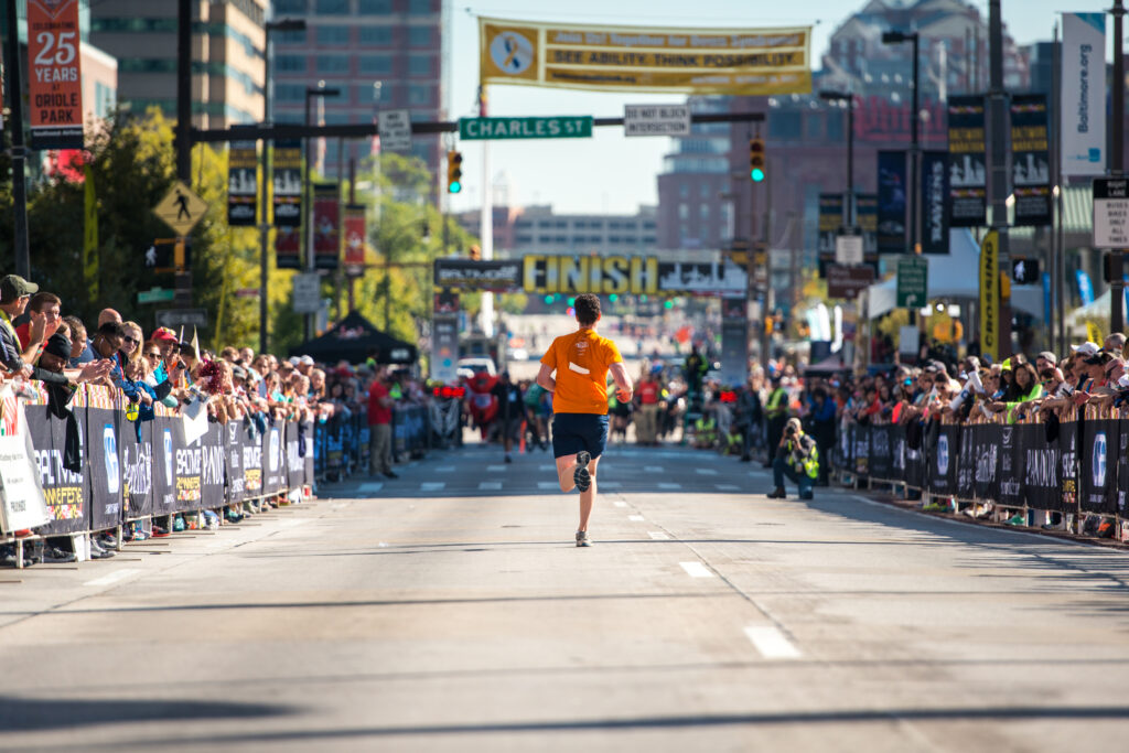 A man crosses the finish line at the Baltimore Running Festival