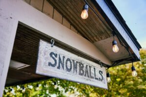 a hanging wooden sign reads "snowballs"